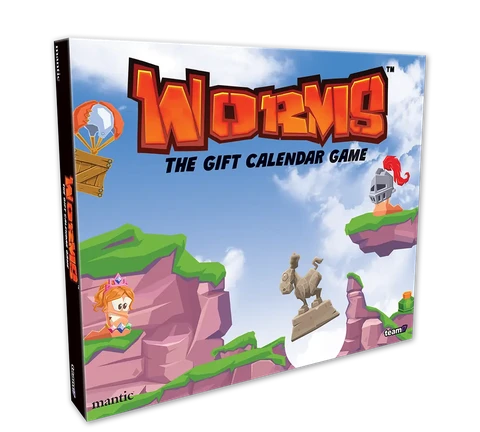 A colorful box for "Worms: The Gift Calendar Game" features a vibrant illustration of cartoonish landscapes with green hills and rocky cliffs. Prominent characters include a pink worm wearing a crown and a knight, both positioned on the cliffs, while a hot air balloon floats in the sky. The title is boldly displayed at the top, emphasizing the festive theme of the advent calendar.