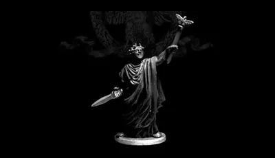 A 28mm scale miniature of Caesar Imperator stands prominently against a dark background. The figure is cast in white metal, showcasing intricate details such as a laurel crown and flowing robes. In one hand, he holds a sword, while the other is raised, delicately supporting a butterfly, symbolizing peace or transformation. The base is circular, providing stability to the figure, which is sculpted with a sense of grandeur and historical significance.