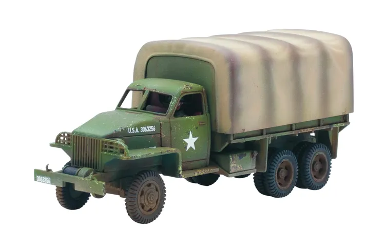 A military-style truck with a green body and a camouflaged canvas cover over the cargo area. The truck features a white star insignia on the side and has visible weathering and paint wear, indicating use. It has six wheels, with the front wheels showing a distinct tread pattern.