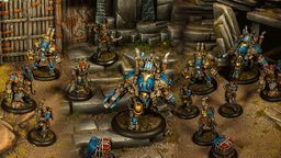 A group of Cygnar miniatures is depicted in a detailed tabletop setting, showcasing the Gravedigger Auxiliaries unit. In the foreground, a character heavy warjack named Beaker stands prominently, adorned in blue and gold armor, with various mechanical features. Surrounding it are several elite veterans, including a female commander with red hair and a rifle, an ogrun captain, and a unit of Gravedigger Commandos, all featuring a mix of blue and gold uniforms, set against a backdrop of stone steps and a weathered door.