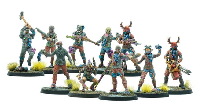 The image features a group of ten colorful, post-apocalyptic miniatures from the Fallout: Factions game. Each figure is intricately detailed, showcasing a variety of weapons and outfits that reflect a rugged, irradiated world. The miniatures stand on round bases adorned with tufts of grass, emphasizing their vibrant paint jobs and unique designs, which include elements like masks, armor, and makeshift gear.