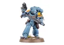 A Space Wolf Blood Claw miniature stands in a dynamic pose, wielding a chainsword in one hand and a pistol in the other. The miniature is painted in a striking blue color with yellow shoulder pads, showcasing intricate details and textures. It is mounted on a round base with a grassy terrain effect, emphasizing its role in the Warhammer 40,000 universe.