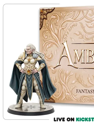 Ornate gold and cream-colored plaque with intricate vine and leaf embellishments framing the text. The plaque reads: "THE AMBER CROWN FANTASY FOOTBALL HIGHBORN ELF." A small, faceted amber-colored gem is embedded near the center. Below the plaque, part of a person's leg is visible, wearing blue jeans and a black sneaker. At the bottom of the image, green text on a black background reads: "LIVE ON KICKSTARTER JUNE 29 — 5 PM CEST."