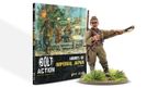 A book titled "Armies of Imperial Japan" from Warlord Games is prominently displayed, featuring a colorful cover illustration depicting Japanese soldiers in action, with a backdrop of explosions and military equipment. The book is positioned upright, showcasing its spine and cover, while a detailed 28mm miniature of a Japanese soldier is placed in the foreground, emphasizing the theme of the game. The text on the cover highlights the book's focus on World War II wargaming rules for the Imperial Japanese Army.