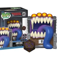 A Funko POP collectible features a Dungeons and Dragons Mimic designed as a treasure chest with a wide, gaping mouth filled with sharp teeth and a long, purple tongue. The Mimic is brightly colored, with orange accents on top, and is accompanied by a D20 die in front, showcasing intricate designs. The packaging displays the Funko logo and the number "423," indicating its series.