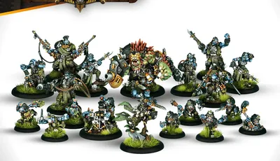 A collection of miniatures from the Southern Kriels Kithguard Army for Warmachine, featuring various trollkin jungle fighters. Prominent figures include Lead Captain Grimtusk, a fierce warlock, and Chomper, a dire troll, alongside Captain Grindstone and several infantry units. The miniatures are detailed, showcasing vibrant colors and dynamic poses, set against a simple background that highlights their intricate designs.