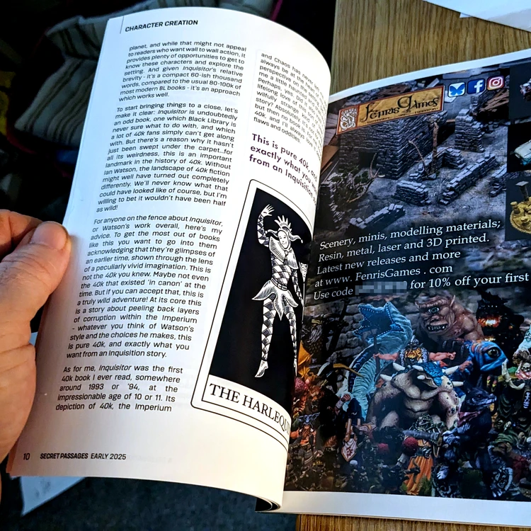 A hand holds open a page from the publication
