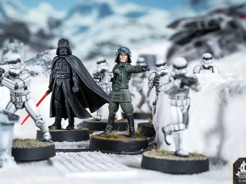 A detailed scene features Darth Vader standing prominently with his red lightsaber drawn, dressed in his iconic black armor and cape. Flanking him are two Stormtroopers, one aiming a blaster, set against a snowy landscape with scattered debris and structures. The miniatures are mounted on circular bases, showcasing their intricate designs and the dynamic pose of the characters.