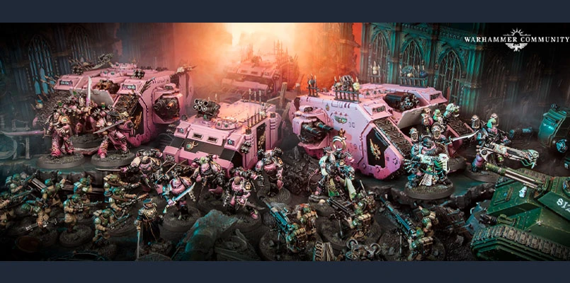 The image showcases a vibrant display of Emperor's Children miniatures from the Warhammer 40,000 universe, prominently featuring a variety of models in striking pink and purple hues. In the foreground, several infantry units are posed dynamically, equipped with futuristic weapons, while behind them, two large armored vehicles are parked, adorned with intricate details and similar color schemes. The backdrop features a dark, atmospheric setting with hints of gothic architecture and dramatic lighting, enhancing the overall sense of chaos and grandeur associated with the Slaanesh faction.