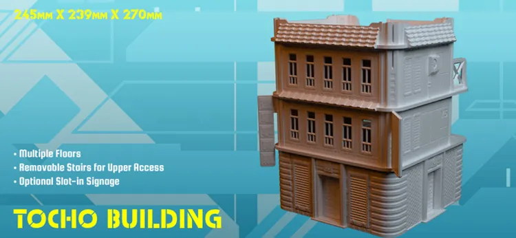 A detailed 3D model of the Tocho Building, showcasing a three-floor structure with a textured roof and multiple windows. The building features removable stairs for upper access and includes optional slot-in signage for customization. The model is presented against a blue geometric background, emphasizing its dimensions of 245mm x 239mm x 270mm.