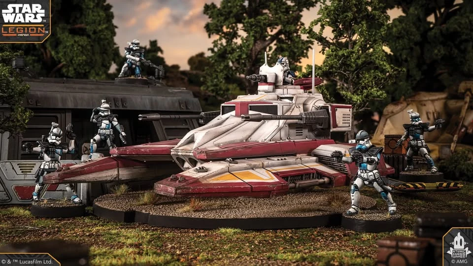 A detailed miniature of the TX-130 Saber-class fighter tank is prominently displayed, featuring a sleek design with a white and red color scheme, equipped with a turret and twin laser cannons. Surrounding the tank are several clone troopers in distinctive armor, posed in various stances, suggesting readiness for action. The backdrop includes a dark, futuristic structure and lush greenery, creating a dynamic battlefield scene.