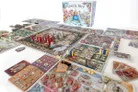 Queen Alice board game box and colorful game pieces on illustrated boards.