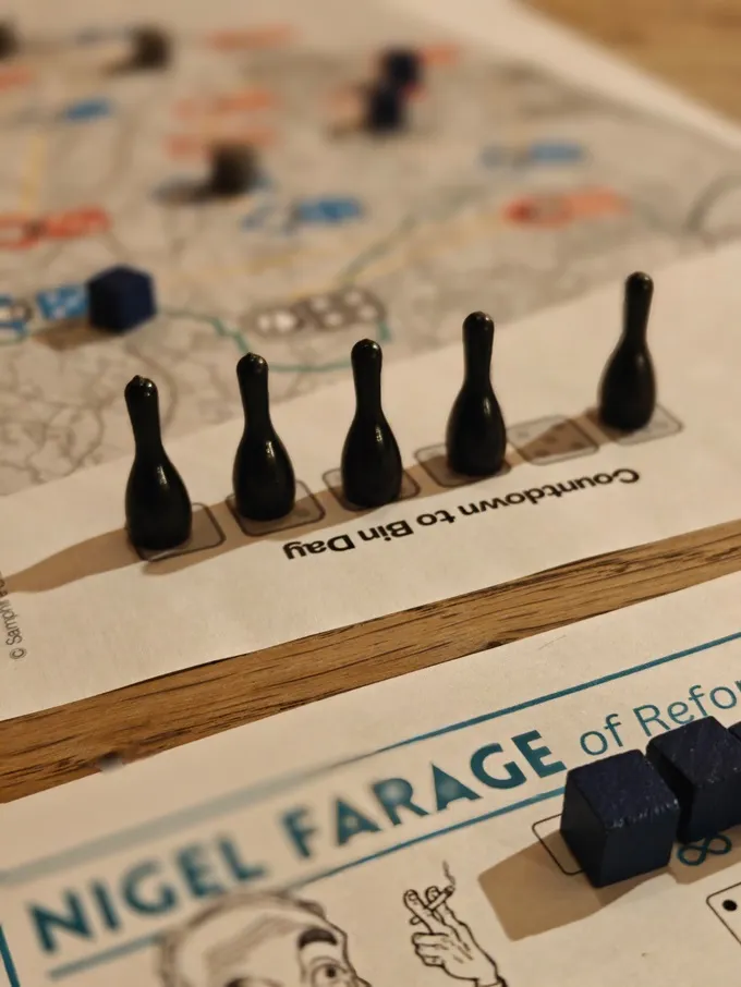 Five black bowling pin-shaped pieces on a board with text "Countdown to Bin Day" and "FARAGE of Reform".