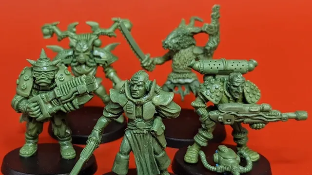 A group of five 28mm scale sci-fi miniatures is displayed against a bright red background. The figures include a Space Commando wielding a rifle, a Starchild with a distinctive helmet, an Assault Goar holding a sword, a Space Orc with a large gun, and a Voidborn equipped with various gadgets. Each miniature features intricate details and a classic old-school aesthetic, showcasing the unique character and charm of the RT Adventurer Pack II from Satyr Art Studios.