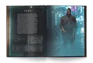 A two-page spread from the "Replicant Rebellion" book features a character profile for "Tank," a rugged figure standing in a rain-soaked, neon-lit urban environment. The left page includes text detailing Tank's attributes, specialty, and character project, while the right page showcases a striking illustration of Tank, who has a mohawk and wears a dark, textured coat. The background is blurred, enhancing the atmospheric feel of the dystopian setting.