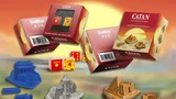 Catan game boxes, dice, and miniatures in Egypt, China, Greece, Germany styles.