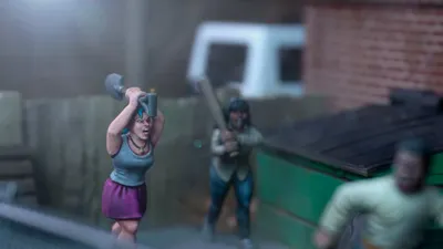 A dynamic scene features three miniature figures in a tense urban setting. In the foreground, a woman with blue hair raises a shovel, while a second figure behind her holds a baseball bat, both appearing ready to confront a threat. A third figure, dressed in a light shirt and blue pants, is seen running away, adding to the sense of urgency in the scene, with a green dumpster and a wooden fence in the background.