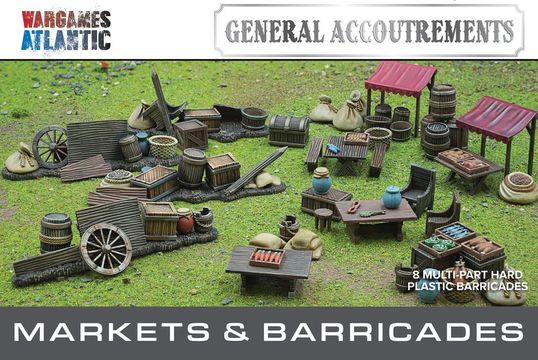A detailed tabletop scene features a variety of marketplace elements, including wooden stalls, barrels, crates, and bags, all set on a grassy surface. The scene showcases multiple tables with assorted food items and decorative pieces, emphasizing the bustling atmosphere of a market. Above the scene, the text "GENERAL ACCOUTREMENTS" and "MARKETS & BARRICADES" is prominently displayed, indicating the theme of the set.