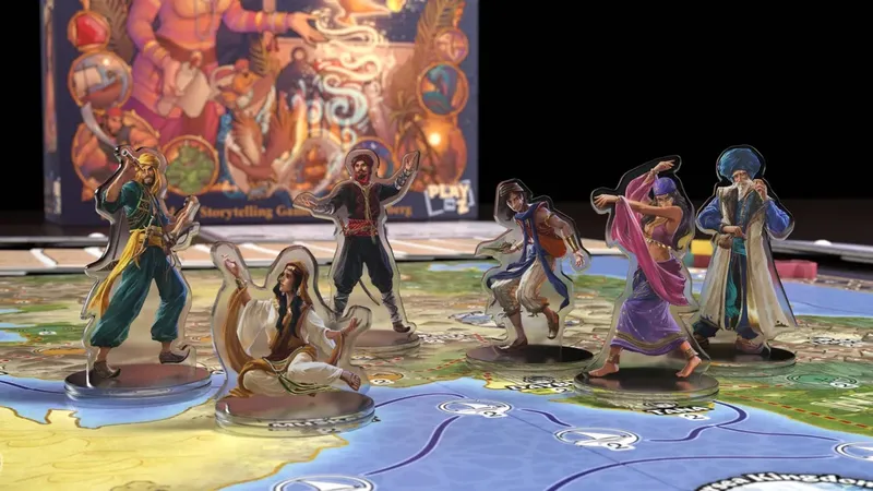 Five character standees are positioned on a colorful game board depicting a map inspired by Arabian Nights. The characters include a seated figure in white robes, a man in a red vest and black pants, a woman in a flowing pink outfit, a man in a blue vest with an orange satchel, and an older man in a blue turban and white robe. In the background, the game box is partially visible, featuring vibrant artwork and the text "PLAY." The board includes various paths and locations, hinting at the adventures players will embark on.