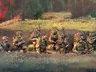 A group of six British army miniatures is depicted in a natural setting, with a backdrop of greenery and a hint of rain. The soldiers are dressed in modern camouflage uniforms and equipped with various weapons, including rifles and gear typical of contemporary military operations. They are positioned in a tactical formation, some seated and others standing, showcasing a range of unique sculpts that highlight their individual poses and details.