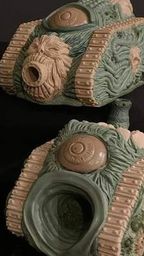 A collection of four unique, grotesque tank models designed for a Chaos army, showcasing a variety of disturbing features such as orifices, boils, and eyeballs. The tanks are sculpted in a mix of green and beige materials, with intricate details on their surfaces, including textured tracks and organic shapes. Each model has a distinct design, emphasizing a visceral aesthetic that aligns with the themes of Chaos in the 41st Millennium.