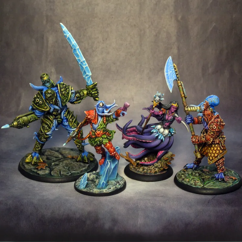 Four intricately designed miniatures from the underwater tabletop skirmish game DeepWars are displayed against a neutral background. On the left, a large, armored figure with a green and blue color scheme wields a large ice sword. Next to it, a humanoid character in vibrant red and green attire gestures dramatically, showcasing blue skin and a confident expression. The third figure, a mermaid-like character with flowing purple hair and a shimmering tail, holds a staff adorned with a glowing orb. On the right, a warrior with a blue head and patterned armor brandishes a large axe, completing the diverse ensemble of characters. Each miniature is mounted on a textured base that reflects an underwater theme.