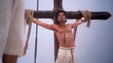 Movie still of crucifixion theme from 'The Life of Brian' where a man is bound to a cross.