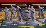 Five detailed gray miniatures are arranged on a colorful game board depicting a map of Europe. The central figure, Dracula, is depicted with a dramatic pose, wearing a flowing cape and extending one arm forward. Surrounding him are four hunters: one holds a stake, another appears to be aiming a weapon, while the others are dressed in Victorian attire, ready for the hunt. The game board features various geographical labels, including the "Tyrrhenian Sea," enhancing the thematic setting of the game.