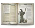 Open book with text and illustration of a robed figure holding a glass orb, accompanied by a small dragon.