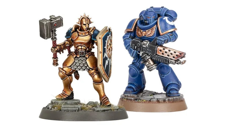 A detailed miniature of a Stormcast Eternal stands on the left, wearing ornate armor with a golden finish, holding a large hammer in one hand and a shield emblazoned with a lightning symbol in the other. To the right, a blue-armored Infernus Space Marine is depicted, equipped with a bolter and showcasing intricate details on its armor. Both miniatures are positioned on textured bases with patches of grass, emphasizing their dynamic poses.