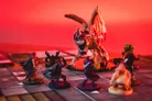 Miniature figures on a board with a red-lit dragon and adventurers.
