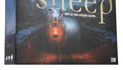 A board game box titled "The Sheep" features a menacing sheep holding a lantern, set against a dark, eerie forest backdrop. The title is prominently displayed in gold lettering, with the tagline "DON'T LET THEM CATCH YOU SLEEPING" beneath it. The overall color scheme is dark, with shades of blue and green, enhancing the horror-comedy theme of the game.