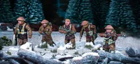 Three British and Canadian winter infantry figures are depicted in a snowy landscape, surrounded by patches of grass and rocks. Each figure is dressed in warm winter gear, with various poses: one holds a rifle, another has a sidearm, and the third is equipped with a machine gun. The background features dark green trees, enhancing the wintery atmosphere of the scene.