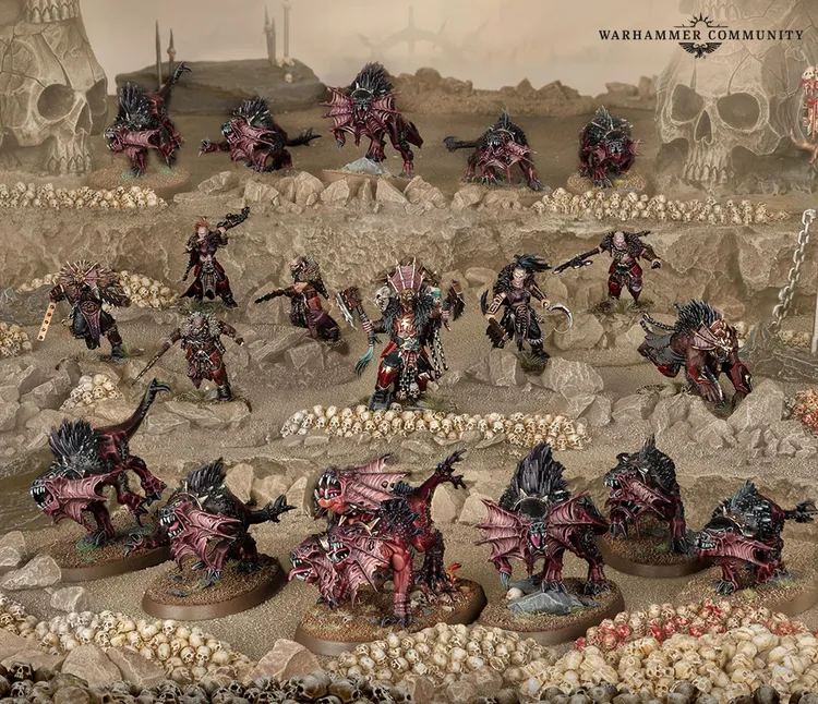 A dynamic scene showcases a variety of new Khornate miniatures set against a desolate, skull-laden landscape. Central to the composition is the Deathbringer, a formidable warrior adorned in dark armor, wielding a massive axe and a spiked shield, flanked by several Flesh Hounds and their three-headed alpha, Karanak. Surrounding them are additional warriors, all intricately detailed and painted in shades of red and black, emphasizing their menacing presence in this chaotic battlefield.