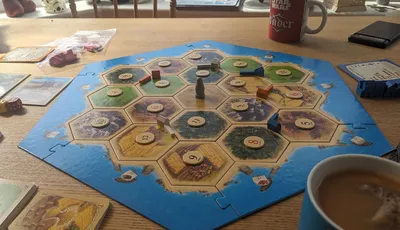 The Catan board laid out as  advised for beginners. On a dining table with tea