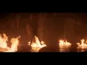Fires burning on dark water at night
