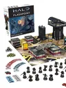 A boxed set for Halo: Flashpoint titled "Feet First into Hell" is prominently displayed, featuring artwork of soldiers in combat. Surrounding the box are 18 detailed miniatures of Orbital Drop Shock Troopers, along with a play mat depicting an urban warzone, several buildings, and various game components including dice, tokens, and cards. The scene is organized, showcasing the miniatures in a dynamic layout, emphasizing the tactical elements of the game.