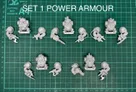 A collection of multipart, white metal miniatures featuring armoured dwarves, arranged on a green cutting mat with a grid pattern. The top row displays various dwarf figures in sci-fi power armour, each equipped with different weapons, including a drill and firearms. The text "SET 1 POWER ARMOUR" is prominently displayed above the miniatures, indicating the theme of this set.