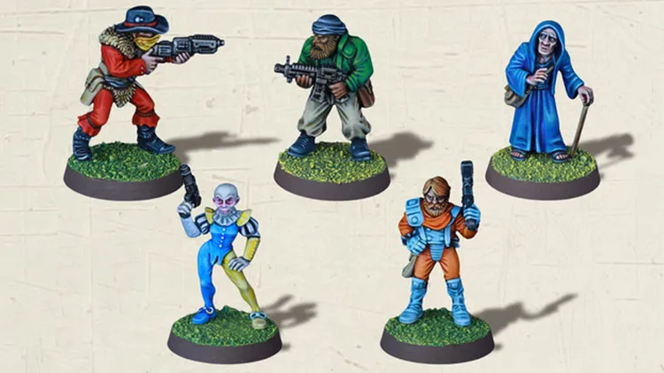 Five detailed miniatures are displayed on circular bases with grassy textures. The characters include a bearded figure in a green jacket holding a rifle, a cloaked figure with a staff, a humanoid with a colorful costume and a pistol, a character in an orange jumpsuit wielding a blaster, and a figure in blue attire. Each miniature showcases intricate paintwork, highlighting their unique features and poses.