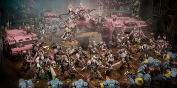 The image features a dynamic scene filled with a multitude of Emperor’s Children miniatures from the Warhammer 40,000 universe, showcasing their vibrant pink and purple color scheme. In the foreground, a diverse array of Chaos Space Marines, adorned with ornate armor and chaotic symbols, engage in battle, while a towering, menacing figure looms behind them, possibly a Daemon Engine or a warlord. Several vehicles, including armored transports, are also present, adding to the chaotic atmosphere of the battlefield, which is set against a dark, atmospheric backdrop. The overall composition emphasizes the flamboyant and hedonistic nature of the Emperor’s Children, reflecting their devotion to Slaanesh.