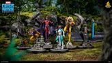 A dynamic scene features several miniatures from the Marvel Crisis Protocol Miniatures Game, prominently showcasing Magneto in a red and purple costume, standing confidently with outstretched arms. Surrounding him are other characters, including a yellow and purple figure resembling Toad, and a blue-skinned character likely representing Mystique. The backdrop consists of a lush, green landscape with trees and rocky formations, enhancing the dramatic setting.