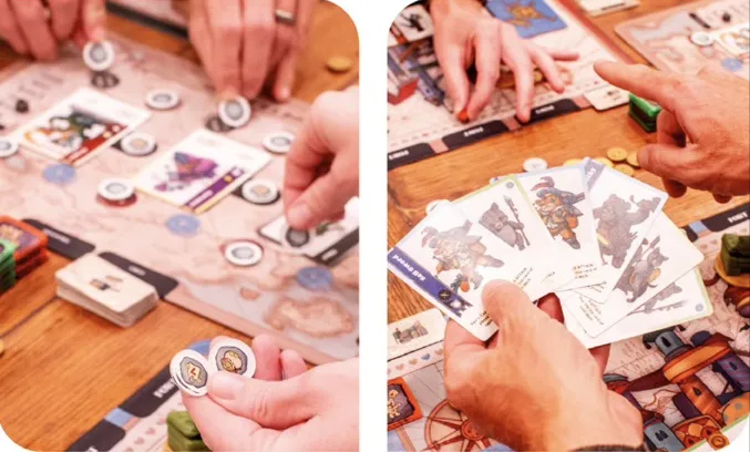 Hands playing a board game with cards, tokens, and a wooden table.