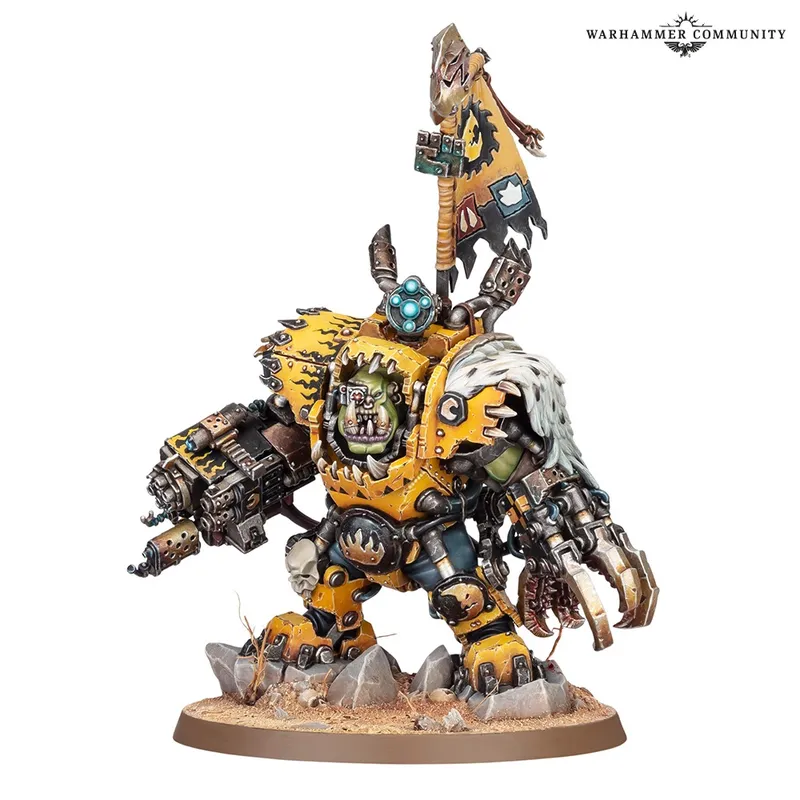 Yellow armored Ork figure with banner, standing on rocky base.