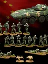A collection of miniature figures representing China's People's Liberation Army (PLA) is displayed against a backdrop of the Chinese flag. The set includes various contemporary infantry soldiers in camouflage uniforms, special operations troops, and unmanned ground vehicles (UGVs). A prominently featured armored vehicle is also present, alongside soldiers in different poses, some standing with weapons, others in prone positions, and two quadruped UGVs positioned on the ground.