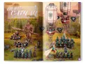 A vibrant spread showcases the new Grand Cathay faction, featuring a variety of intricately detailed miniatures. Prominent in the scene is a large armored figure wielding a weapon, alongside several smaller units adorned in teal and gold, with one character flying on a dragon-like creature. Above, two ornate hot air balloons with decorative patterns float, adding a fantastical element to the lush, green backdrop.
