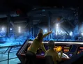 Two people in futuristic uniforms stand at a brightly lit control console. One points toward a large, illuminated space station or ship structure outside a window. Screens display technical data, including a glowing circular icon and text.