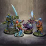 Four intricately designed miniatures from the underwater tabletop skirmish game DeepWars are displayed against a neutral background. On the left, a large, armored figure with a green and blue color scheme wields a large ice sword. Next to it, a humanoid character in vibrant red and green attire gestures dramatically, showcasing blue skin and a confident expression. The third figure, a mermaid-like character with flowing purple hair and a shimmering tail, holds a staff adorned with a glowing orb. On the right, a warrior with a blue head and patterned armor brandishes a large axe, completing the diverse ensemble of characters. Each miniature is mounted on a textured base that reflects an underwater theme.