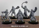 A group of five Drudge Slayer miniatures stands on circular bases, each showcasing unique designs and weaponry. The figures are muscular and armored, featuring various mechanical elements and menacing expressions. They are posed in dynamic stances, with some wielding large weapons like spiked flails and others displaying intricate details in their armor, all rendered in a gray color that highlights their features against a simple background.