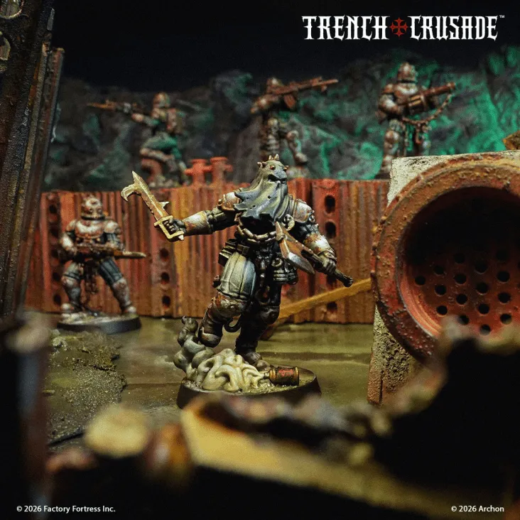 A detailed scene from the Trench Crusade game features a central miniature, a warrior clad in dark armor with a hood and a weapon raised, standing on a grotesque base that resembles twisted, organic forms. In the background, several other soldiers are positioned, armed and ready, against a backdrop of rusted metal and crumbling terrain, evoking a grim and war-torn atmosphere. The image is framed by the game's title, "TRENCH CRUSADE," at the top, enhancing the thematic focus on the conflict between the forces of Heaven and Hell.