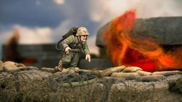 A detailed miniature of a U.S. soldier, Hershel W. 'Woody' Williams, is depicted in action, equipped with a flamethrower on his back and wearing a helmet and military uniform. He is positioned on a textured base that resembles a battlefield, with a backdrop of flames and smoke suggesting a combat environment. The scene captures the intensity of the Pacific theatre during World War II.